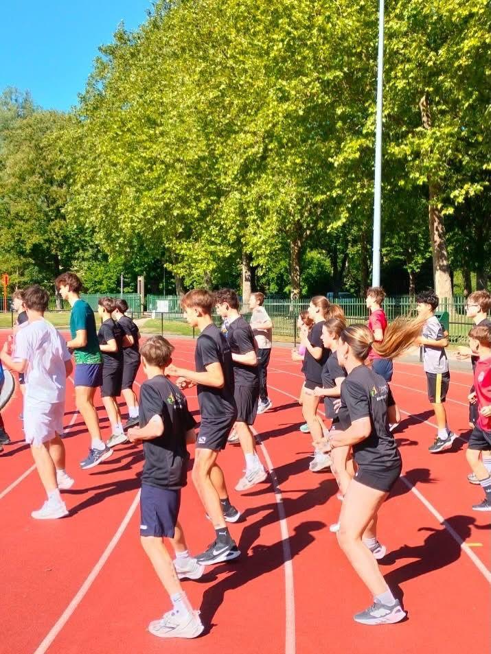 Leerlingen peddelen in kajaks op het water tijdens een schooluitstap
