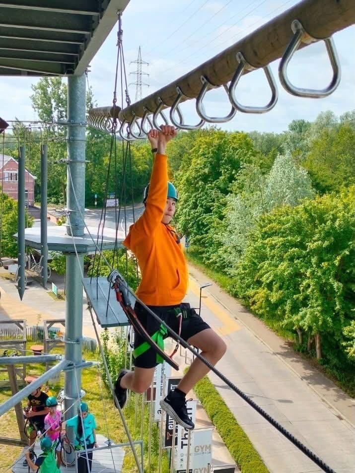 Leerling abseilt van een klimtoren tijdens een avontuurlijke schoolactiviteit