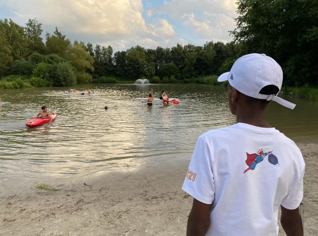 Leerlingen doen kajak- en supactiviteiten op een meer tijdens een schooluitstap