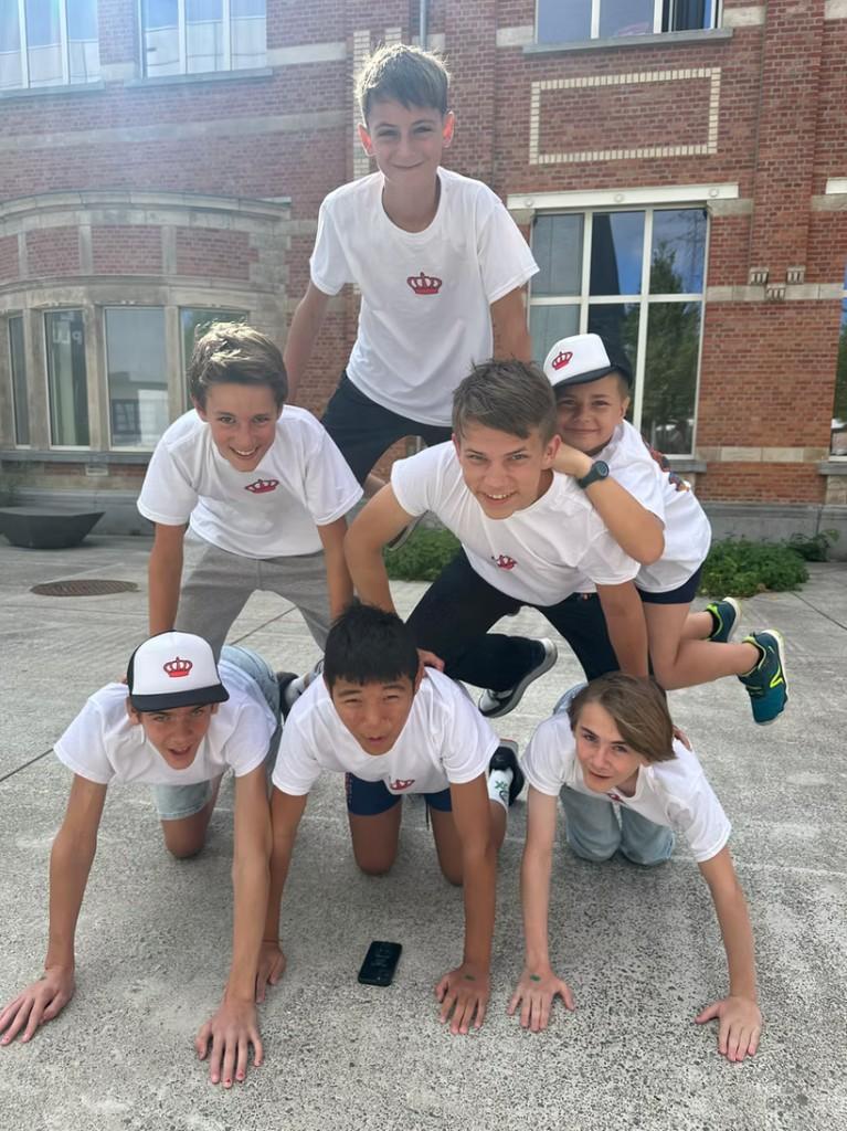 Leerlingen vormen een menselijke piramide als teambuildingactiviteit op de binnenkoer