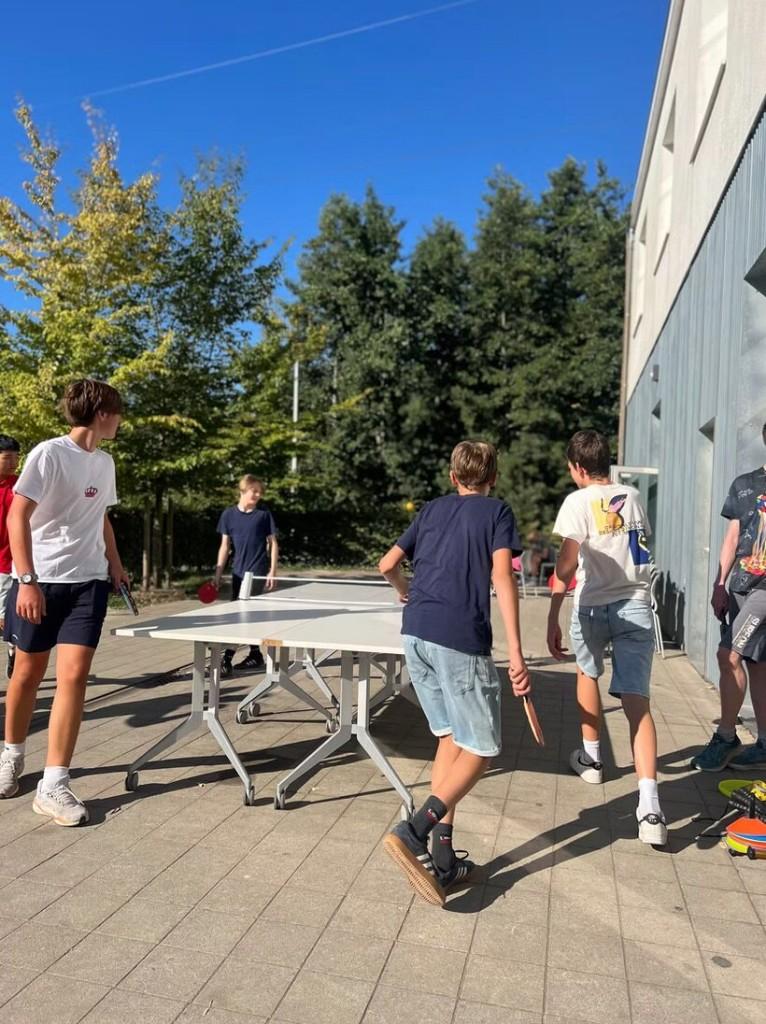 Leerlingen spelen tafeltennis op de binnenkoer