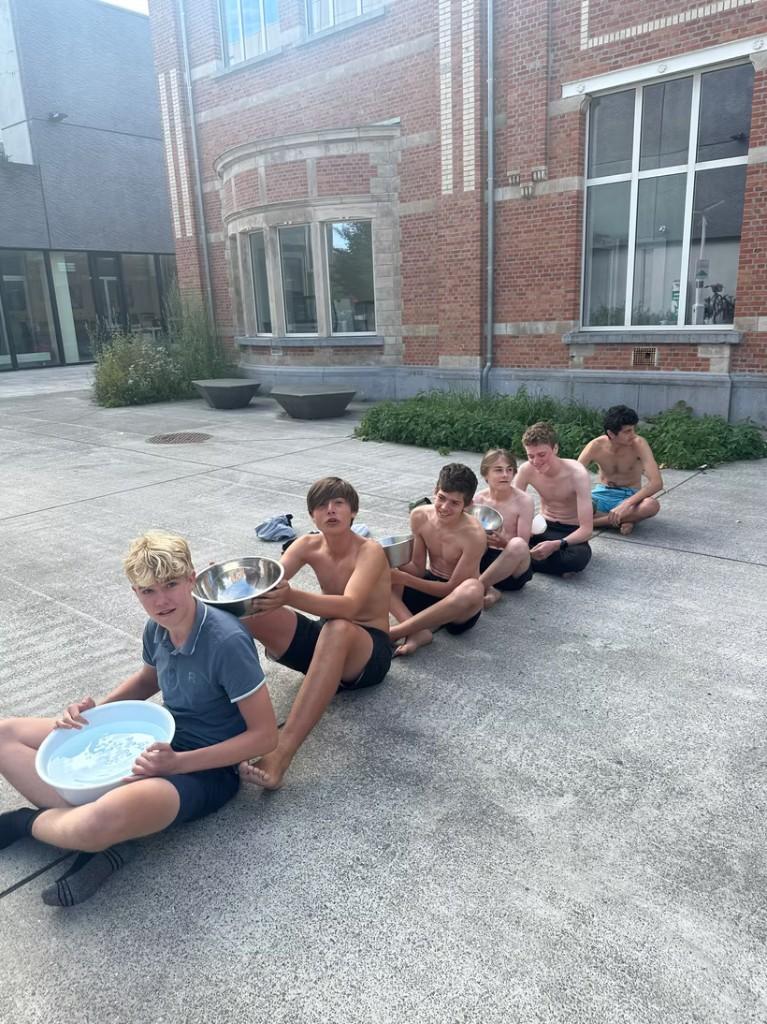 Leerlingen doen een waterspel als teambuildingactiviteit op de binnenkoer